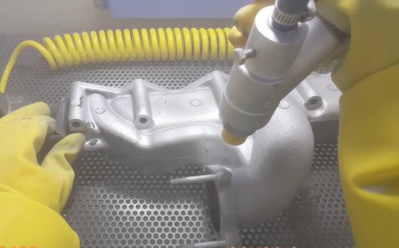 Phun cát làm sạch chi tiết máy móc